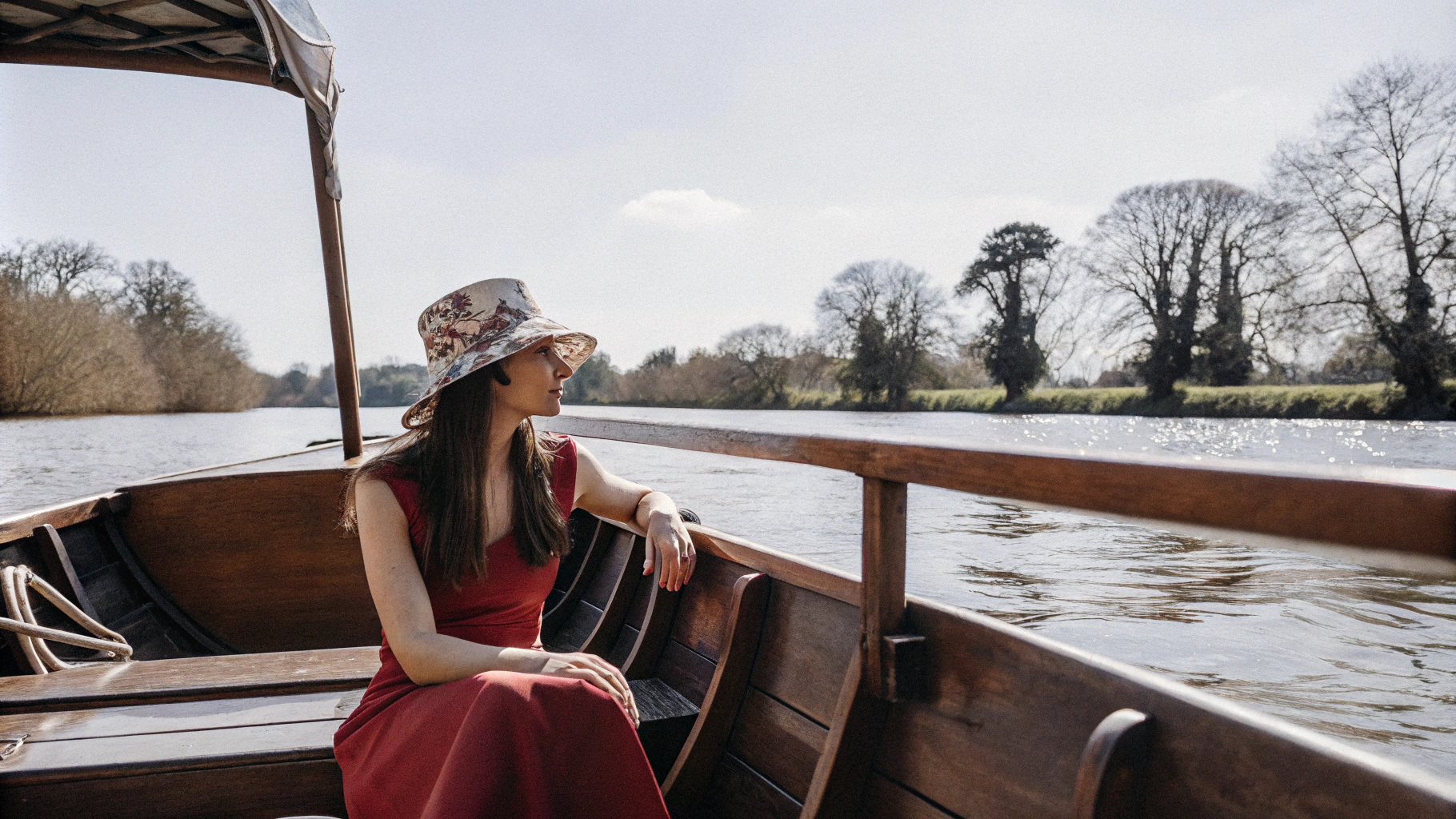 AI generated image by Red Panda AI: Une jeune femme avec un chapeau fleuri et une robe rouge sur un bateau naviguant sur un fleuve